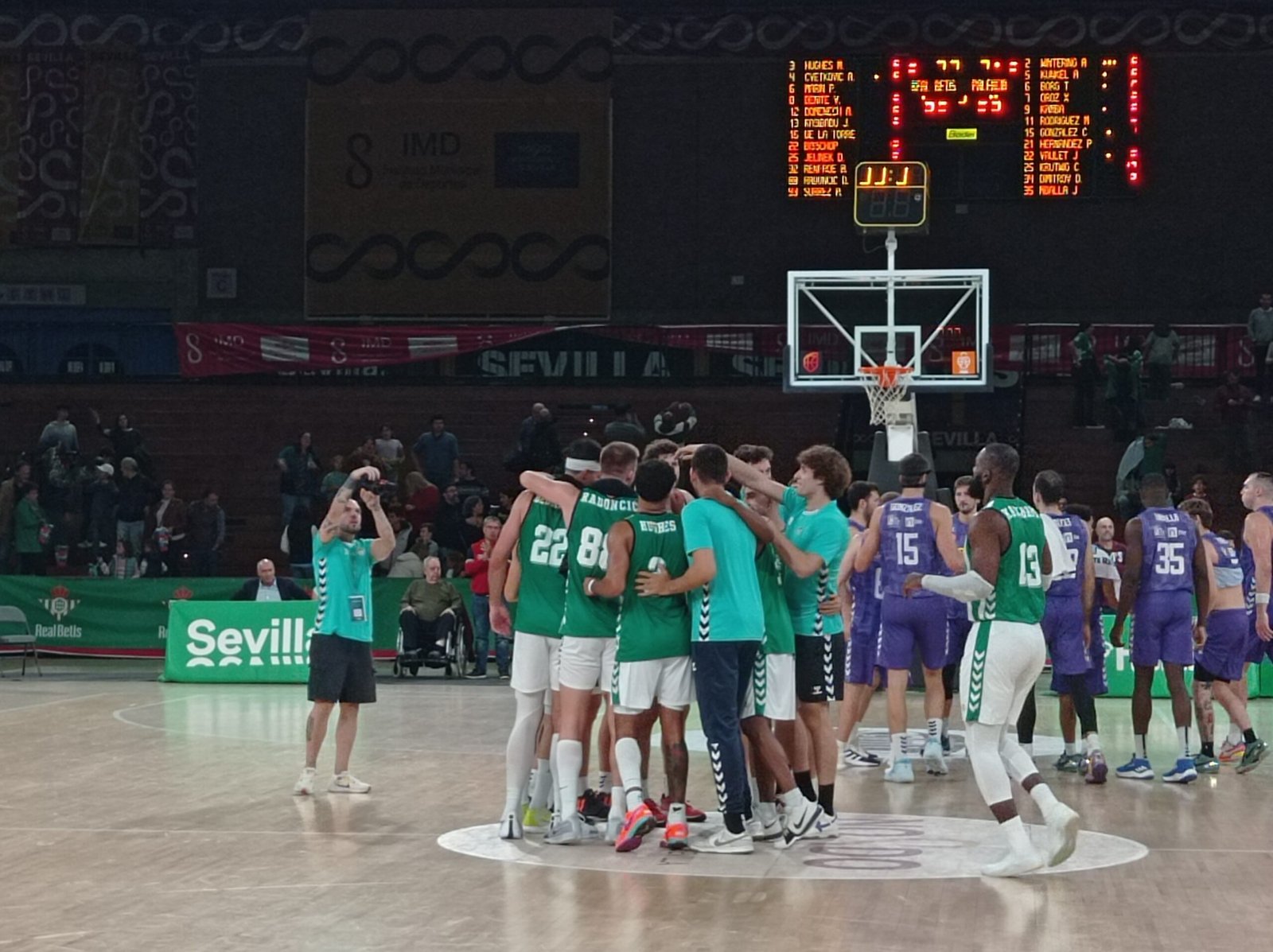 Los jugadores del Real Betis y los de Palencia hacen un corro tras la victoria bética en la Jornada 5 de Primera FEB.