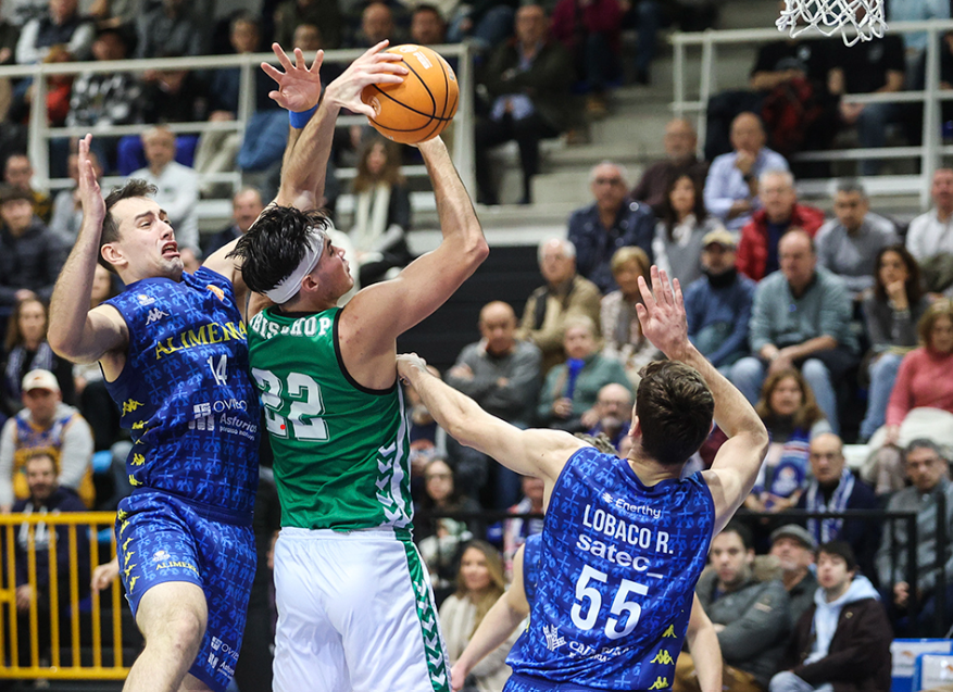 DeBisschop pelea con Sanz y Lobaco un rebote durante el partido de la jornada 21 de Primera FEB entre Oviedo y Real Betis Baloncesto. | Imagen X: @RealBetisBasket