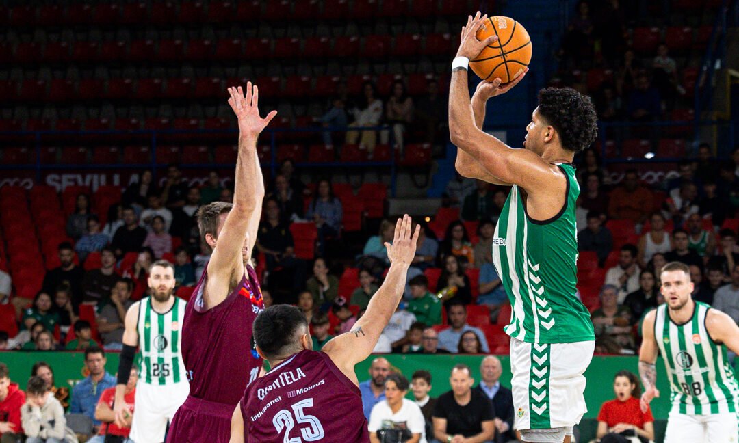 Mark Hughes lanza ante Brodziansky y Quintela, durante la jornada 30 de Primera FEB que enfrentó al Real Betis Baloncesto y a Monbus Obradoiro. | Imagen: Antonio Martín